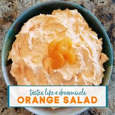 an orange salad in a bowl with the words tastes like a dreamsice on it