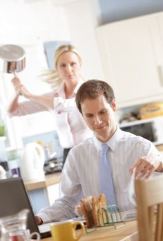 a man sitting at a table with food in front of him and a woman standing behind him