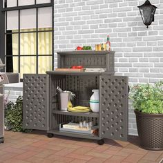 an outdoor bbq with grill, sink and potted plants on the side walk