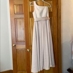 a white dress hanging on a wooden door