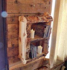 a wooden shelf with books and candles on it