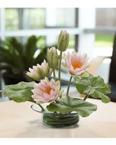 a glass vase filled with white flowers on top of a table