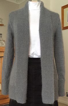 a woman's gray cardigan sweater is displayed on a mannequin