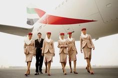 several people in suits and ties walking towards an airplane