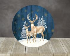 two deer standing next to each other in front of a wooden background with snowflakes