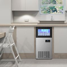 a kitchen with white cabinets and a silver refrigerator freezer next to a step ladder