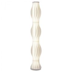 a tall white vase sitting on top of a wooden table next to a light fixture