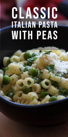 pasta with peas and parmesan cheese in a black bowl on a wooden table