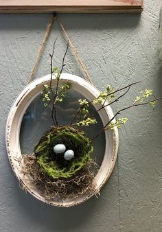 a bird's nest hanging on a wall with two eggs in it