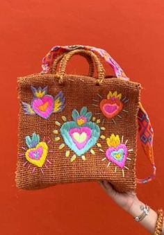 Get ready to elevate your style with this gorgeous Mexican Embroidered Bag, handmade with love and care in Mexico! Crafted from natural fiber, this bag features stunning Corazon Mexicano embroidery that pays homage to traditional Mexican artistry. The hand-knitted strap from Chiapas, Mexico adds a unique and authentic touch to this one-of-a-kind piece. This Boho Chic Bag is not only beautiful but also versatile. Wear it for your everyday outings, a night out in town, or even bring it along to th Embroidered Brown Vacation Bag, Brown Embroidered Vacation Bag, Artisan Embroidered Beach Bag, Embroidered Natural Tote Shoulder Bag, Natural Embroidered Tote Bag, Natural Color Embroidered Tote Bag, Bohemian Natural Embroidered Straw Bag, Eco-friendly Embroidered Bags As Gifts, Bohemian Embroidered Straw Tote Bag