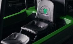 the interior of a green and black car with seats in it's center console