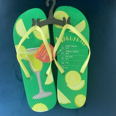 a pair of green flip flops with lemon slices and martini on the bottom one