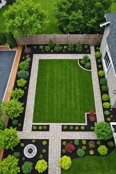 an aerial view of a backyard garden with grass and flowers in the center, surrounded by trees