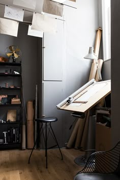 a room with several hanging lights above it and a desk in the corner next to a chair