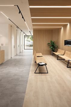 an empty waiting room with two benches and a tv