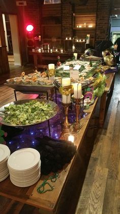 a long table filled with lots of food on top of a wooden table covered in plates