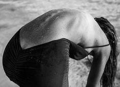 black and white photograph of a woman bent over in the water