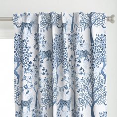 a curtain with blue and white animal print on it, hanging in front of a window