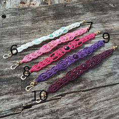 four different colored lace lanyards sitting on top of a wooden table