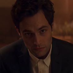 a man in a suit and tie looking at the camera with an intense look on his face