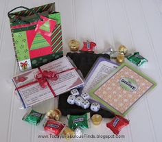 a pile of assorted candy and cards on top of a white table next to a bag