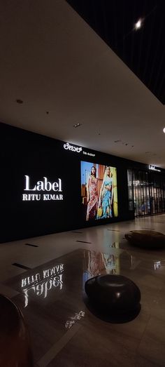 an empty lobby with large black and white signs on the wall, and round sculptures in front of them