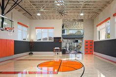 an indoor basketball court with orange and black accents