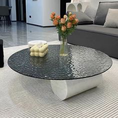 a glass table with flowers on it in a living room