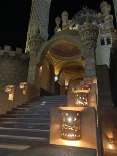 the stairs lead up to an elaborate castle like building with lights on it's sides