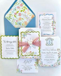 the wedding stationery is laid out on top of each other, including an envelope with a bow