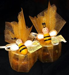 two bees sitting on top of each other in glass vases with tags attached to them