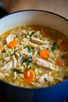 a bowl of chicken and rice soup with carrots