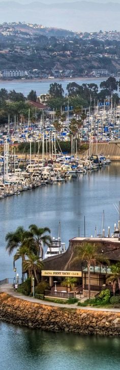 an island in the middle of a body of water with many boats docked on it