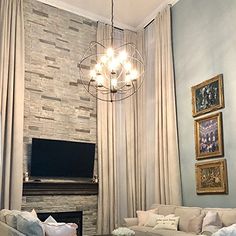 a living room filled with furniture and a flat screen tv mounted on the wall next to a fire place