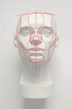 a white mannequin head with red lines on it