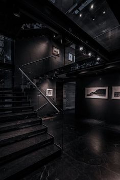 an empty room with some stairs and pictures on the wall in front of it at night