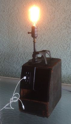 a light that is sitting on top of a wooden box with a cord attached to it