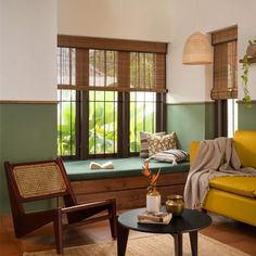 a living room filled with furniture next to a window covered in bamboo blindes and pillows