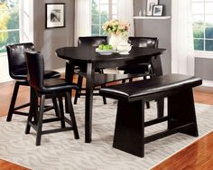 a dining room table with four chairs and a bench