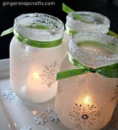 three mason jars with lights in them on a tray