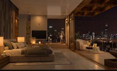 a large bedroom with a view of the city at night from it's windows