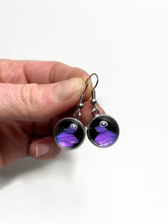 These are handmade real butterfly wing earrings made with the species Graphium weiskie These earrings are a beautiful black and purple colour. I use a clear Domed glass that is set in a silver tone setting creating beautiful framed butterfly wing earrings.  Each piece is truly one of a kind.  All of my butterflies are ethically sourced.  Every butterfly has lived a full life so no wing is perfect. Size: 14mm All my jewelry is handmade in Calgary, Alberta in my home studio. My earrings are lightw Real Butterfly Wing Jewelry, Butterfly Wing Jewelry, Purple Dangle Earrings, Real Butterfly Wings, Butterfly Wing Earrings, Wing Earrings, Butterfly Wings, Glass Earrings, My Jewellery