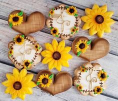 decorated cookies in the shape of heart and sunflowers on a wooden table top