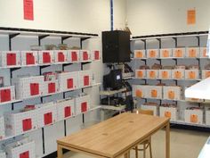 a room filled with lots of shelves and boxes on the wall next to a wooden table