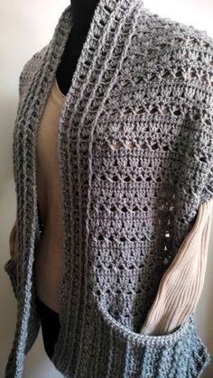 a crocheted shawl is displayed on a mannequin