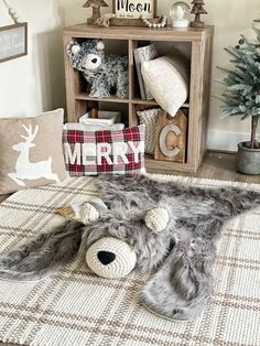 a stuffed animal laying on top of a bed next to a christmas tree and other decorations