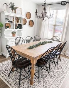 a dining room table with black chairs and white walls