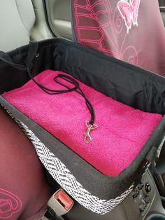 the inside of a car seat with pink towels in it