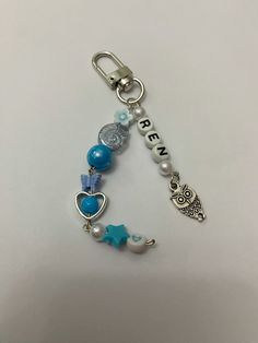 a key chain with an owl, star and heart charm on it's side