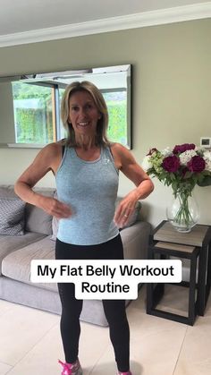 a woman standing in front of a couch with her hands on her hips and the words, my flat belly workout routine